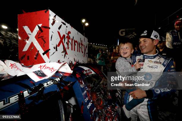 Kyle Larson, driver of the DC Solar Chevrolet, poses with his son, Owen, after applying the winner's sticker during the NASCAR Xfinity Series...