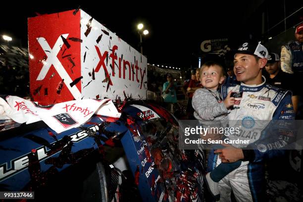 Kyle Larson, driver of the DC Solar Chevrolet, poses with his son, Owen, after applying the winner's sticker during the NASCAR Xfinity Series...