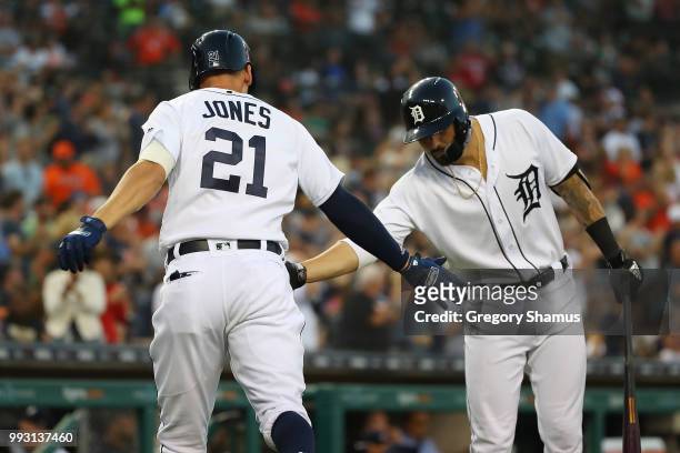 JaCoby Jones of the Detroit Tigers celebrates his eighth inning solo home run with Nicholas Castellanos while playing the Texas Rangers at Comerica...