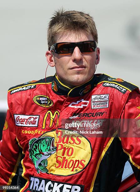 Jamie McMurray, driver of the Bass Pro Shops Chevrolet, stands next to his car on the grid during qualifying for the NASCAR Sprint Cup Series Autism...
