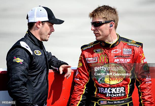 Casey Mears, driver of the Red Bull Toyota, talks with Jamie McMurray, driver of the Bass Pro Shops Chevrolet, as they stand on the grid during...