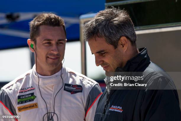 Dane Cameron, L, and Juan Pablo Montoya, of Colombia, talk in the pits before practice for the IMSA WeatherTech Series race at Canadian Tire...