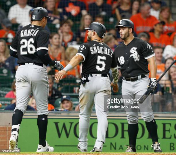 Avisail Garcia of the Chicago White Sox reveives congratulations from Yolmer Sanchez and Daniel Palka after hitting a home run in the ninth inning...