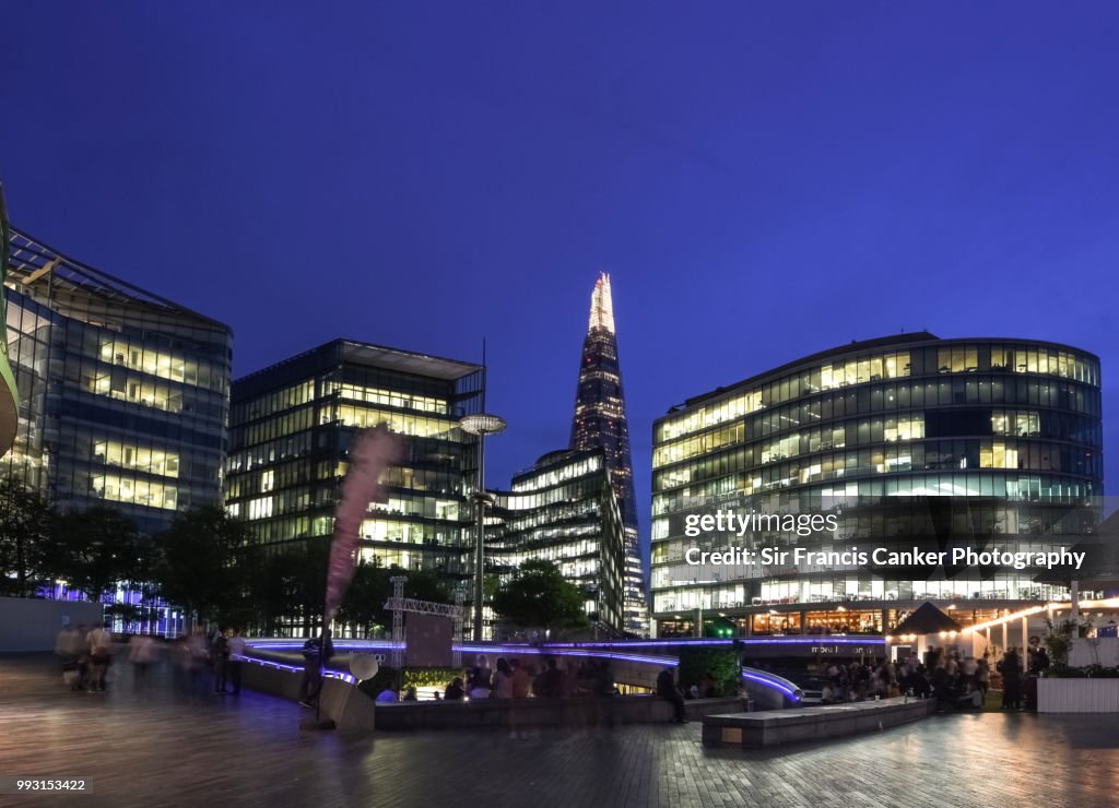 Close-up image of the Shard among futuristic high rise buildings illuminated at dusk in London, England, UK
