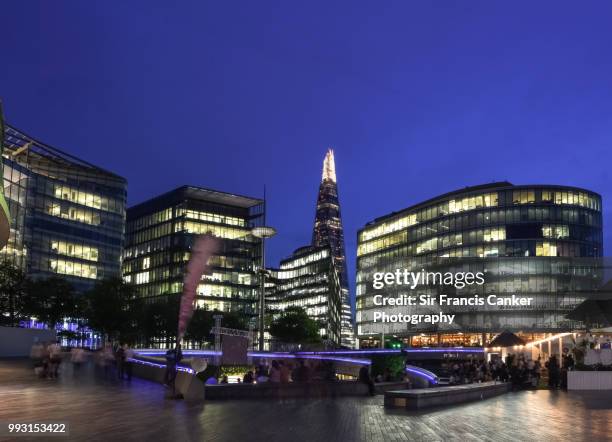 close-up image of the shard among futuristic high rise buildings illuminated at dusk in london, england, uk - thames embankment stock pictures, royalty-free photos & images