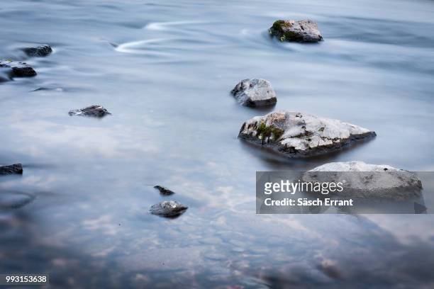river flows around rocks - errant stock pictures, royalty-free photos & images