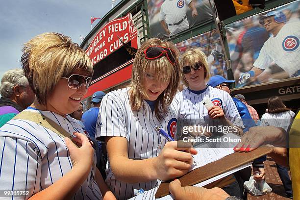 Chicago Cubs fan Jessica Polte signs a petition urging the team to move their spring training camp out of Arizona prior to the Cubs game against the...