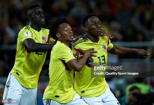 Yerry Mina of Colombia celebrates scoring his side's first goal with his teammates Juan Cuadrado and Davinson Sanchez during the 2018 FIFA World Cup...