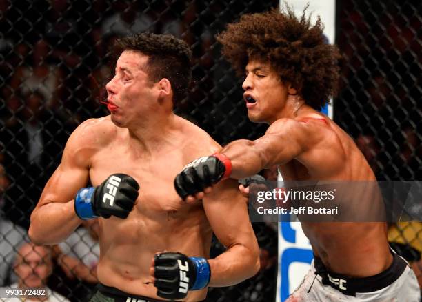 Alex Caceres punches Martin Bravo of Mexico in their featherweight bout during The Ultimate Fighter Finale event inside The Pearl concert theater at...