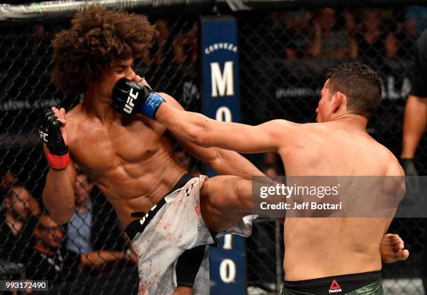 Martin Bravo of Mexico punches Alex Caceres in their featherweight bout during The Ultimate Fighter Finale event inside The Pearl concert theater at...