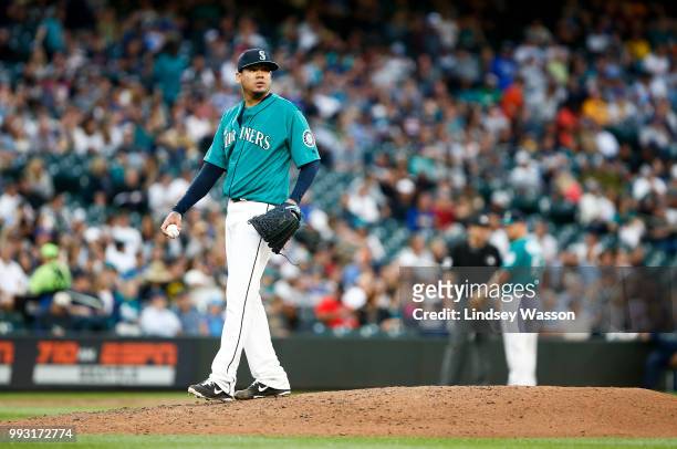 Felix Hernandez of the Seattle Mariners reacts after allowing DJ LeMahieu of the Colorado Rockies to reach first on a wild pitch in the fifth inning...