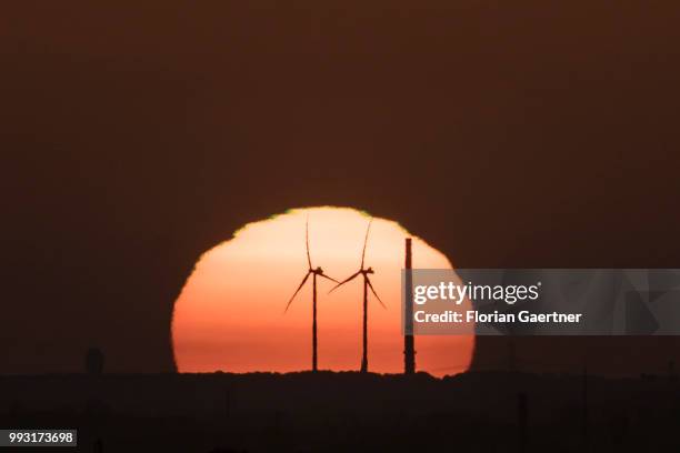 The sun rises behind wind turbines on July 07, 2018 in Berlin, Germany.