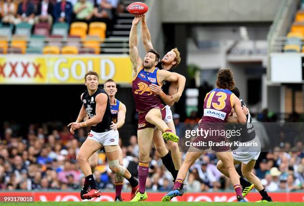 Stefan Martin of the Lions and Andrew Phillips of Carlton challenge for the ball during the round 16 AFL match between the Brisbane Lions and the...