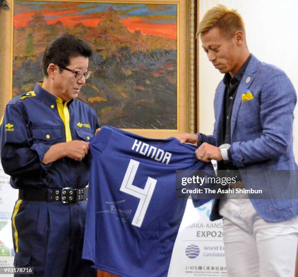 Football player Keisuke Honda presents autographed Japan National team shirt to Osaka Prefecture Governor Ichiro Matsui during his visit to the Osaka...