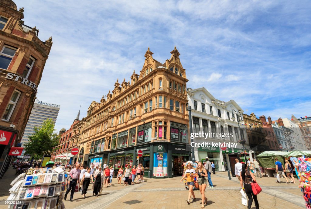 Shoppers walking in a pedestrianised area of Leeds