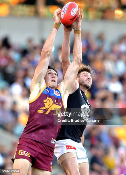 Oscar McInerney of the Lions and Dale Thomas of Carlton challenge for the mark during the round 16 AFL match between the Brisbane Lions and the...