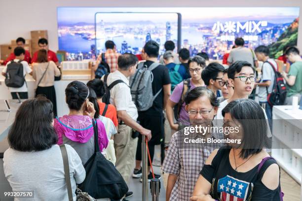 Customers wait in line to purchase Xiaomi Corp. Mi 8 smartphones inside a Xiaomi store in Hong Kong, China, on Friday, July 6, 2018. The tussle...