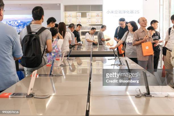 Customers wait in line to attach screen protectors to newly purchased Xiaomi Corp. Mi 8 smartphone inside a Xiaomi store in Hong Kong, China, on...