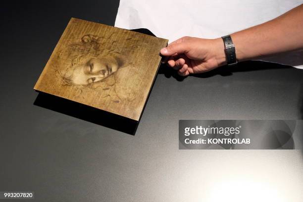 Art curators check the condition of the 'La Scapiliata" by Leonardo da Vinci before the exhibition at Gallerie d'Italia/Palazzo Zevallos in Naples,...