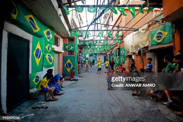 Lebanese children play football in the street next to Brazilian flags in the Ersal district, southern Beirut, prior to the Russia 2018 World Cup...