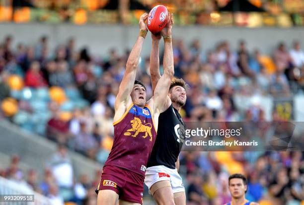 Oscar McInerney of the Lions and Dale Thomas of Carlton challenge for the mark during the round 16 AFL match between the Brisbane Lions and the...