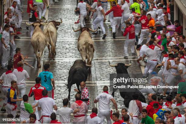 Revellers run with Puerto de San Lorenzo's fighting bulls along Calle Estafeta during the second day of the San Fermin Running of the Bulls festival...