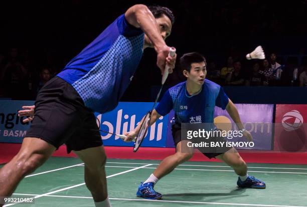 Liao Min-chun and Su Ching-heng of Taiwan hit a return against Takuto Inoue and Yuki Kaneko of Japan during their men doubles semi-final match at the...
