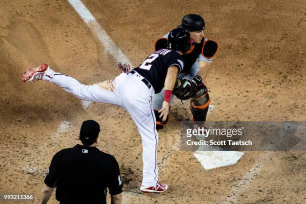 Adam Eaton of the Washington Nationals is tagged out at home plate by J.T. Realmuto of the Miami Marlins during the fourth inning at Nationals Park...
