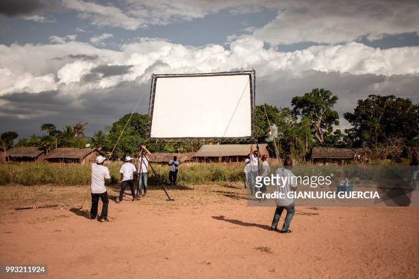 Members of the Italian Agency for Cooperation and development and Mozambican Filmmakers collective AMOCINE set up a giant screen for a public view of...
