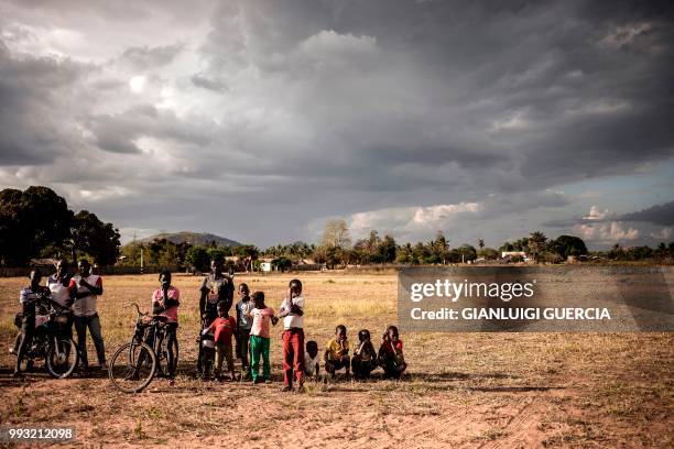 Residents of the northern Mozambique village of Alua look at a giant screen being set up ahead of watching a live broadcasting of the Football World...