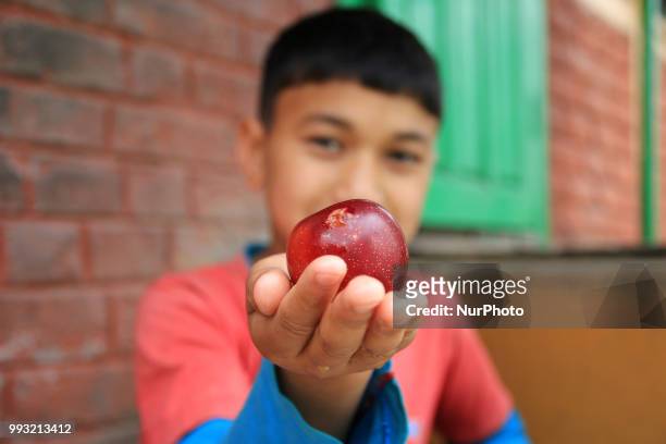 Kid eat fruits outside his house in Manali town , Himachal Pradesh , India on 6th July,2018.Manali is a resort town nestled in the mountains of the...