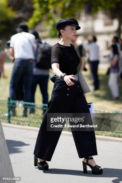 Guest wears a beret hat, a black mesh top, oversized flared pants, black shoes , outside Chanel, during Paris Fashion Week Haute Couture Fall Winter...