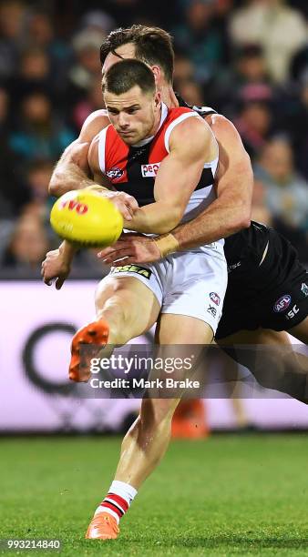 Jack Sinclair of the Saints gets the kick away under pressure from Charlie Dixon of Port Adelaide during the round 16 AFL match between the Port...