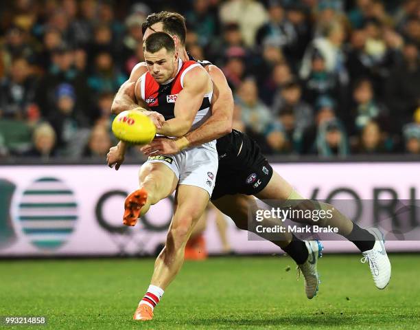 Jack Sinclair of the Saints gets the kick away under pressure from Charlie Dixon of Port Adelaide during the round 16 AFL match between the Port...