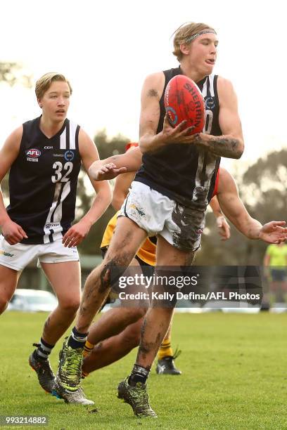 Baxter Mensch of the Geelong Falcons handballs during the round 11 TAC Cup match between Dandenong Stingrays and Geelong Falcons at Shepley Oval on...