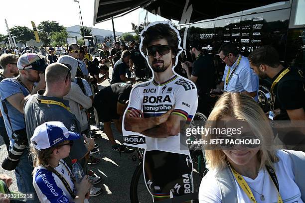 Reporters and staff members gather around Germany's Bora-Hansgrohe cycling team bus, by a lifesize cardboard cutout of Slovakia's Peter Sagan, prior...