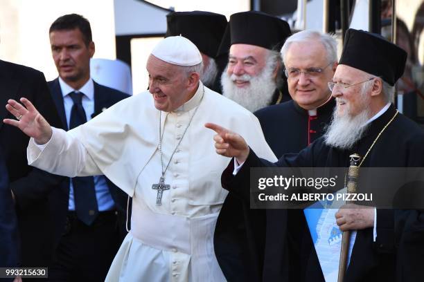 Pope Francis waves to believers next to Ecumenic Patriarch of the Orthodox Church, Bartolomeo I, as he arrives after his mass at the 'Rotonda' on the...