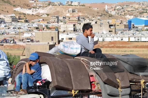 Syrians children wait to leave their refugee camp in the city of Arsal in Lebanon's Bekaa valley on the eastern border with Syria, on July 7 as they...
