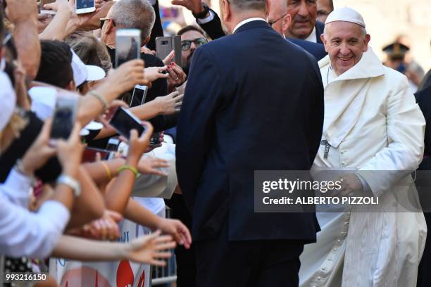 Pope Francis greets believers as he arrives after his mass at the 'Rotonda' on the Lungomare of Bari to meet with other religious leaders at the...