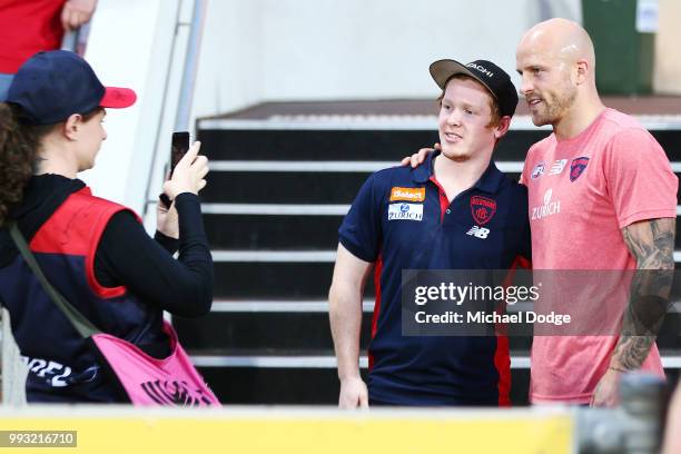 Nathan Jones of the Demons pose with a fan during the round 16 AFL match between the Melbourne Demons and the Fremantle Dockers at TIO Stadium on...