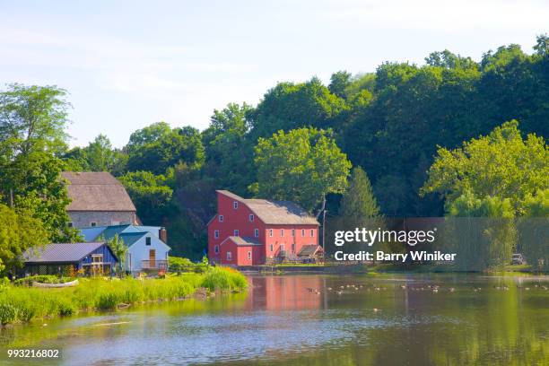 historic red mill on placid river surrounded by trees, in clinton, new jersey - barry wood stock-fotos und bilder