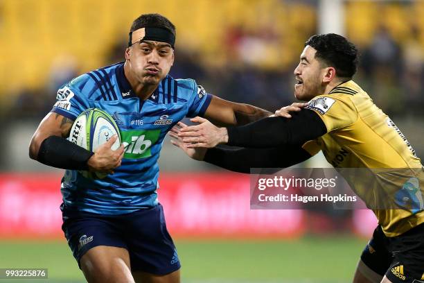 Augustine Pulu of the Blues fends Nehe Milner-Skudder of the Hurricanes during the round 18 Super Rugby match between the Hurricanes and the Blues at...