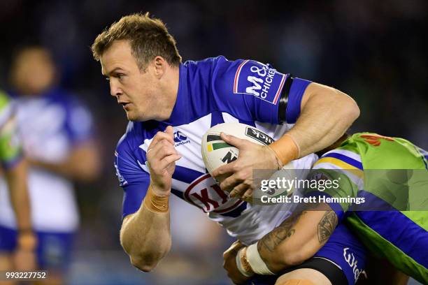 Joshua Morris of the Bulldogs is tackled during the round 17 NRL match between the Canterbury Bulldogs and the Canberra Raiders at Belmore Sports...