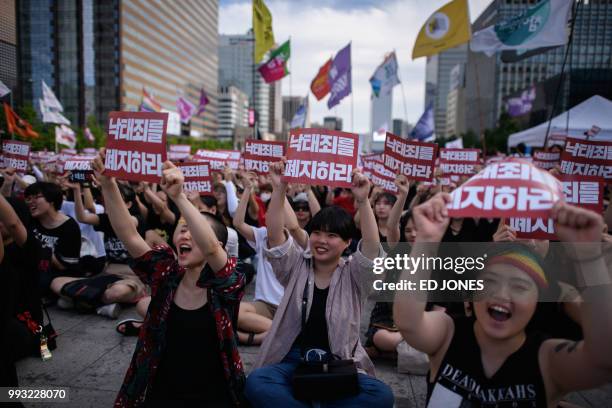 Protesters hold placards reading 'Abolish punishment for abortion' as they protest South Korean abortion laws in Gwanghwamun plaza in Seoul on July...