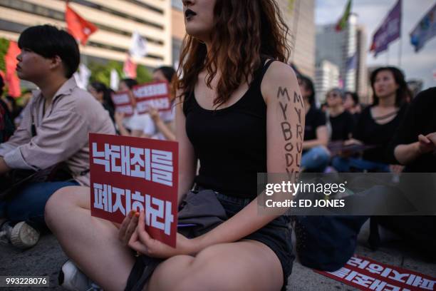 Protesters hold placards reading 'Abolish punishment for abortion' as they protest South Korean abortion laws in Gwanghwamun plaza in Seoul on July...