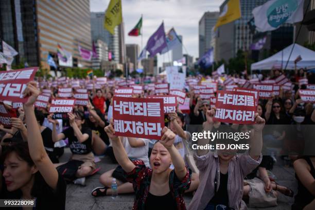 Protesters hold placards reading 'Abolish punishment for abortion' as they protest South Korean abortion laws in Gwanghwamun plaza in Seoul on July...