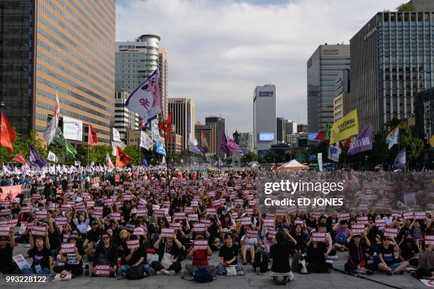 Protesters hold placards reading 'Abolish punishment for abortion' as they protest South Korean abortion laws in Gwanghwamun plaza in Seoul on July...