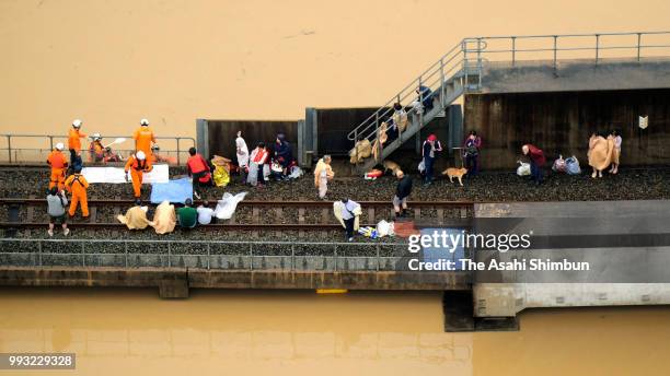 In this aerial image, people are being rescued on the railway track as the area is submerged ue to heavy rain on July 7, 2018 in Kurashiki, Okayama,...