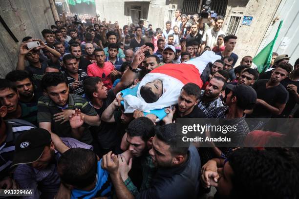 People carry the body of Mohammed Jamal Abu Halima during his funeral ceremony at Shujaiyya neighbourhood of Gaza City, Gaza on July 7, 2018. Abu...