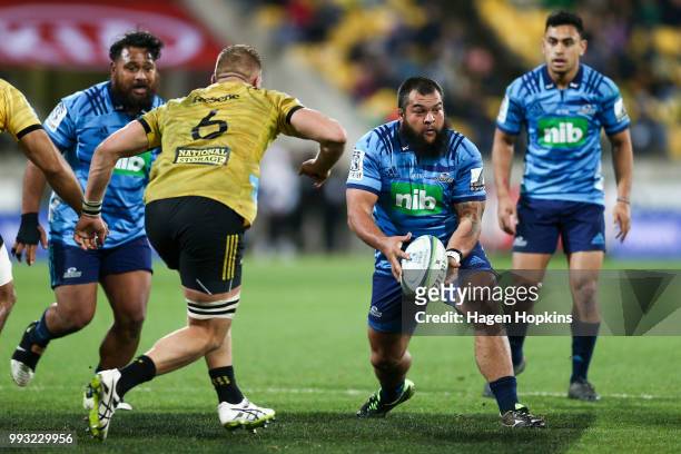 Ross Wright of the Blues looks to pass under pressure from Brad Shields of the Hurricanes during the round 18 Super Rugby match between the...
